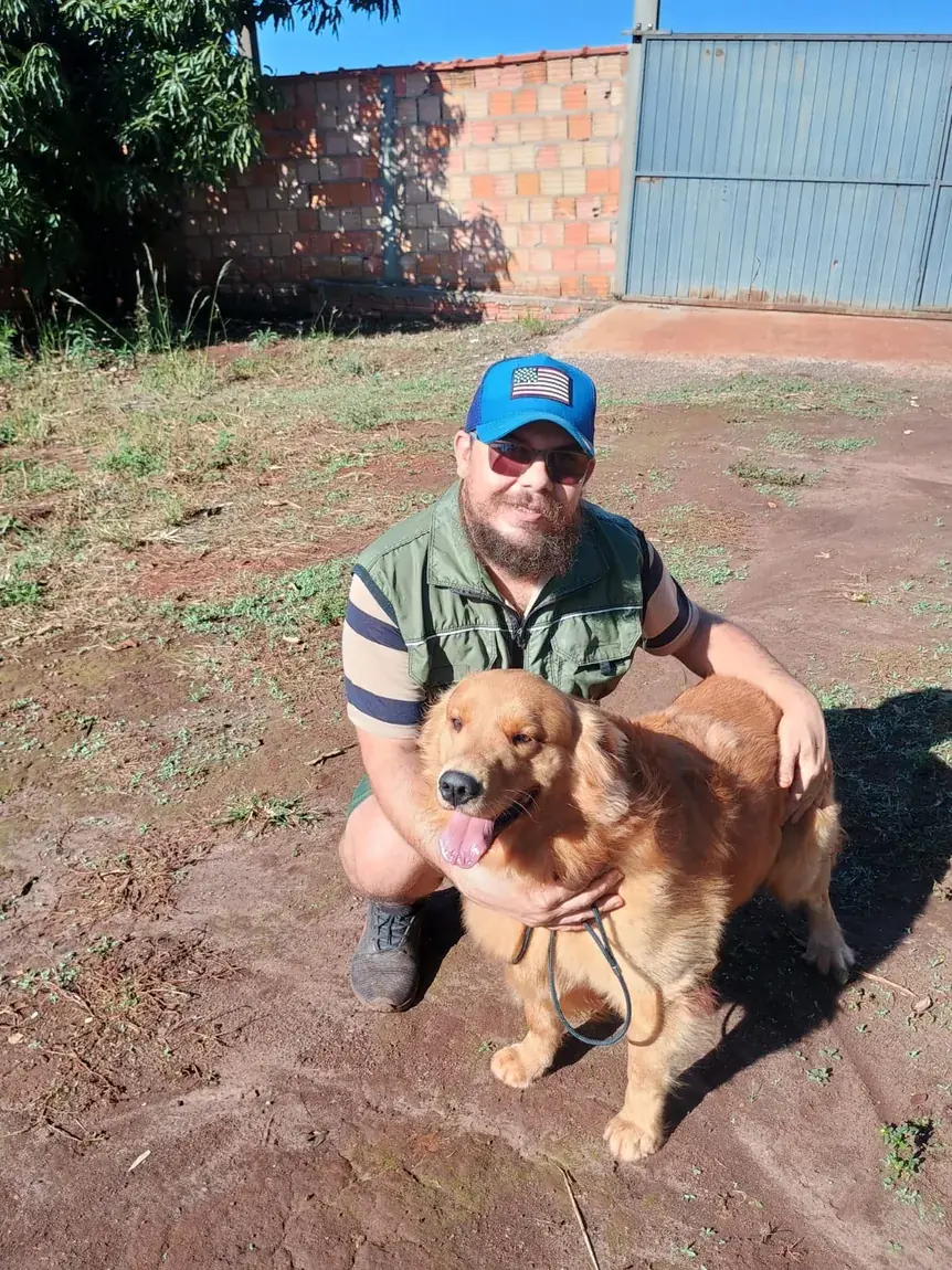 Treinador com golden retriever em área externa